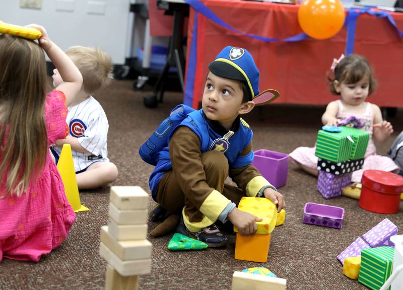 Four-year-old Nivaan Thaker of Westmont, dressed as Chase from Paw Patrol, uses building blocks during a Paw Patrol party at the Indian Prairie Public Library in Darien on Friday, June 28, 2024.