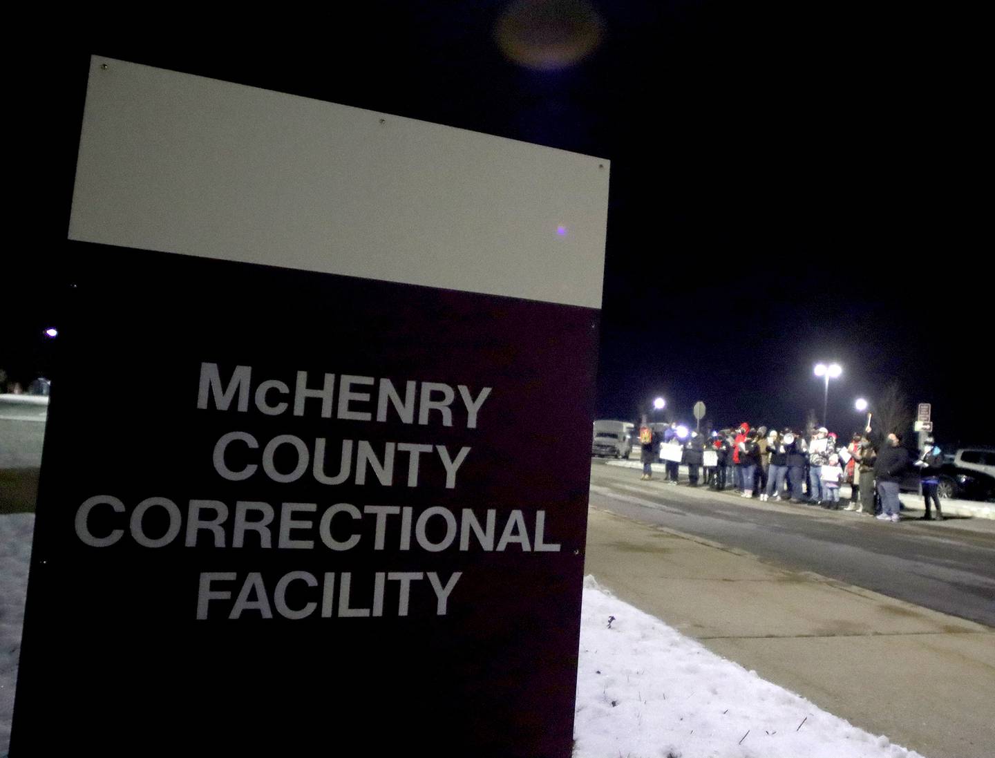 Activists held a candlelight march to the front of the McHenry County Correctional Facility the evening of Wednesday, Dec. 29, 2021, using a bullhorn to offer encouraging words to inmates and detainees. Former detainee Cesar Elizarraraz spoke to those gathered as part of the event arranged by the Coalition to Cancel the ICE Contract in McHenry County.