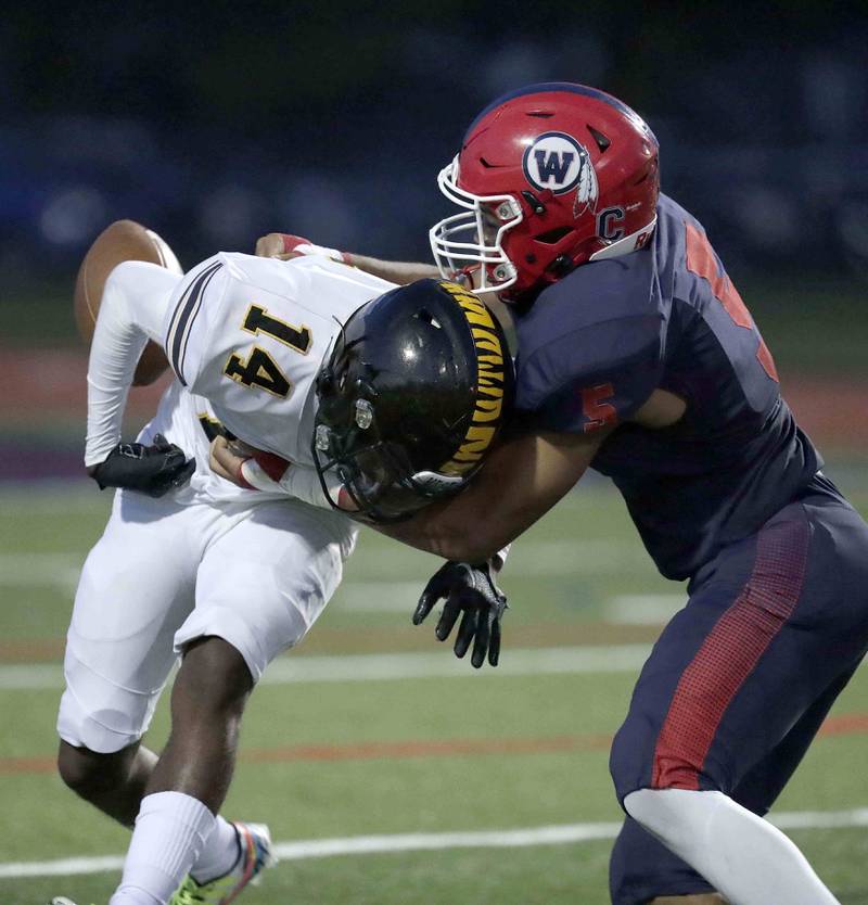 West Aurora's Ezekyel Brooks (5) punches the ball from Joliet West's Marion Starks (14) causing a fumble and touchdown Thursday September 15, 2022 in Aurora.