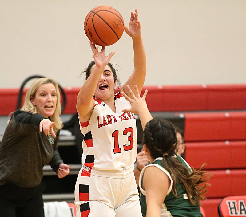 Hall's Mckenna Christiansen (13 shoots a jump shot over St. Bede's Brianna Torres (24) as St. Bede head girls basketball coach Stephanie Mickley directs her to get the rebound on Monday, Nov. 28, 2022 at Hall High School in Spring Valley.