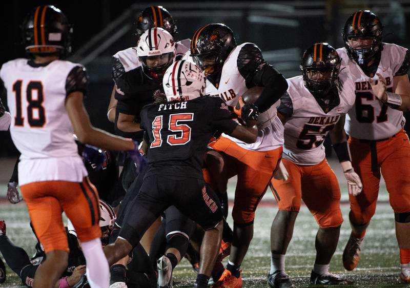 Dekalb's Travis Moore, center, runs the ball as Bradley-Bourbonnais' Jordan Fitch and others make the tackle in a game on Friday, October 10, 2025.