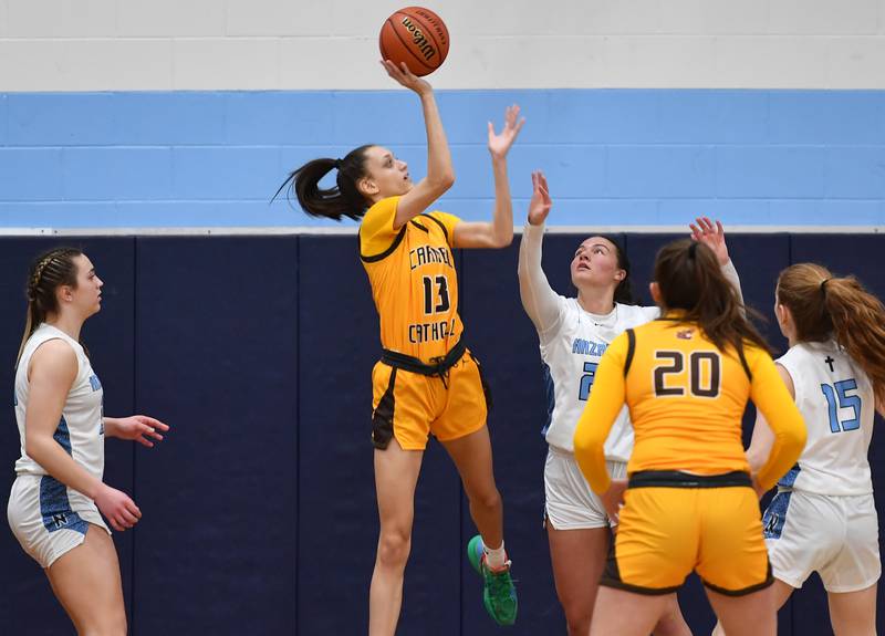 Carmel's Jordan Wood (13) puts up a shot while surrounded by Nazareth Academy defenders Olivia Austin (left), Danielle Scully, and Mary Bridget Wilson (15) during the ESCC conference tournament championship game on Feb. 4, 2023 at Nazareth Academy in LaGrange Park.