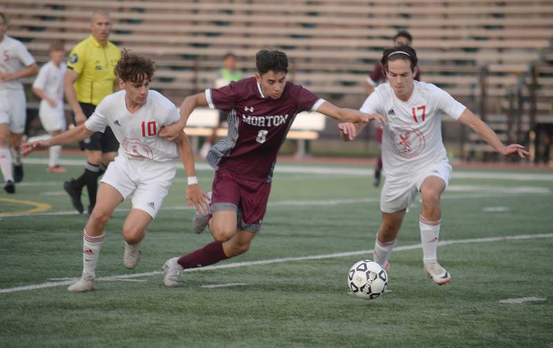 Morton West's Enrique Ayala prevents Naperville Central's (left) Michael White and Clay Scherf  from getting the ball during their home game in Berwyn Monday, Aug. 21, 2023.