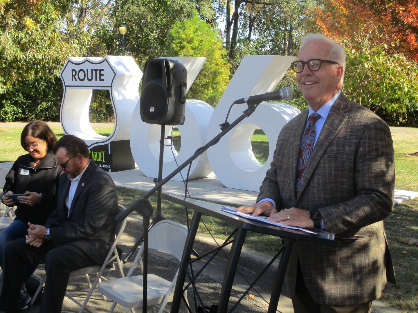 Joliet Mayor Terry D'Arcy talks about changes at the city's Route 66 Park with a Route 66 sculpture in the background.