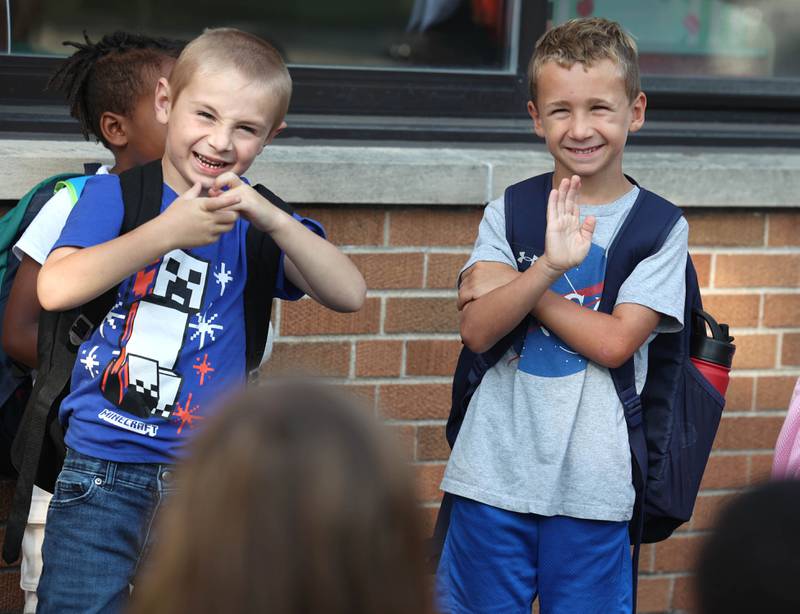 Lincoln Elementary School students wave at their friends as they line up for their first day of classes Wednesday, Aug. 14, 2024, at the school in DeKalb.