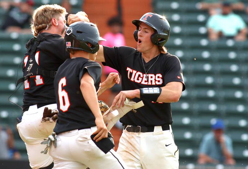 Crystal Lake Central’s Connor Gibour is greeted after coming around to score in supersectional baseball action against DePaul College Prep at Wintrust Field in Schaumburg Monday.