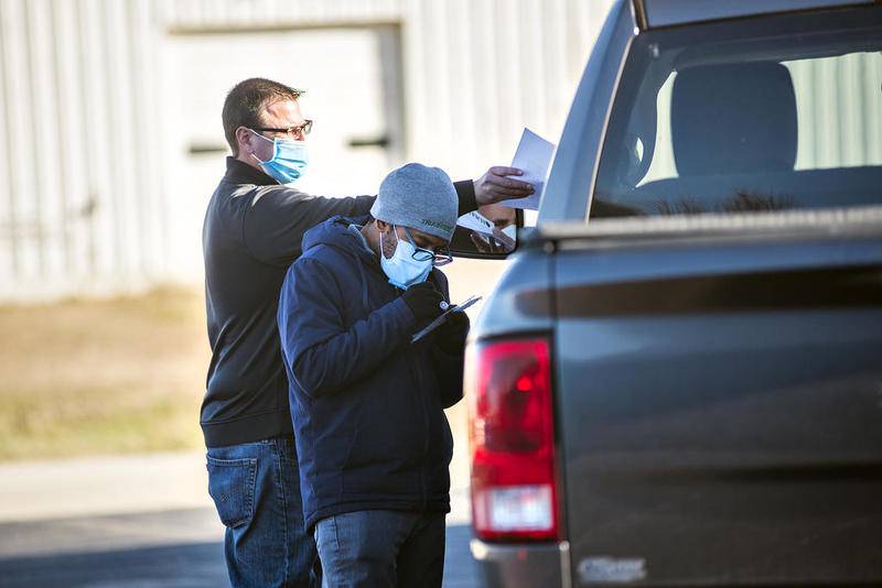 Nick Zeigler (left) and Enrique Jones of the Illinois Department of Public Health check in a patient who’s stopped at the Ogle County Health Department  in Oregon Wednesday for a free COVID-19 test. The group will be at the same place Thursday from  8 a.m. to 4 p.m.