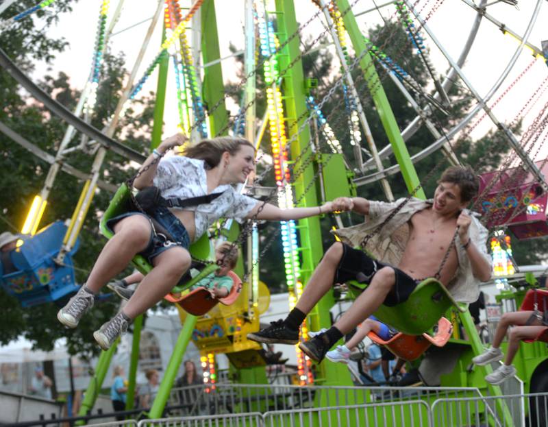 Mari Rager, 15, of Oregon, and Kaleb Graae, 15, of Byron, ride the swings at the Ogle County Fair in Oregon on Thursday, July 31, 2025.