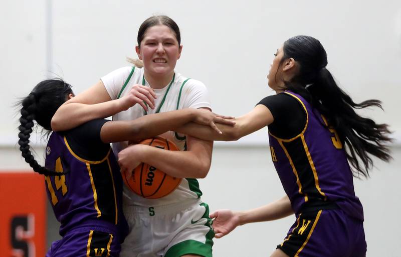 Crystal Lake South's Gaby Dzik tries to hang onto the basketball as she drives to the basket between Wauconda's Alexia Manalo (left) and Wauconda's Alessandra Rodriguez (right) during the Northern Illinois Holiday Classic Championship girl basketball game on Thursday, Dec. 18, 2025, at McHenry High School.