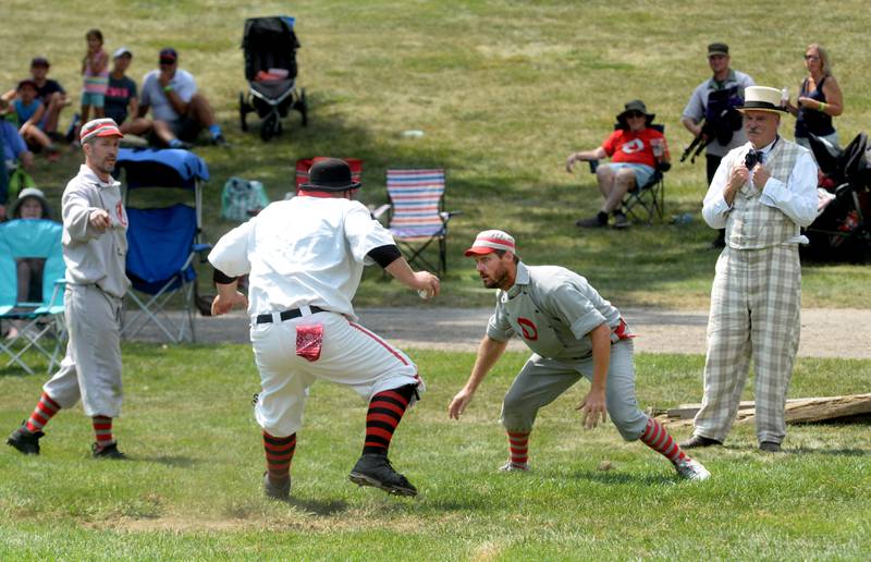 Oregon Ganymede Brett Rogers eyes the Bay City Independent catcher as he tries to avoid the tag at home during the World Tournament of Historic Base Ball held at the Henry Ford Museum's Greenfield Village on Saturday, Aug. 9, 2025. Also pictured is Eric Berg (left) and the umpire.