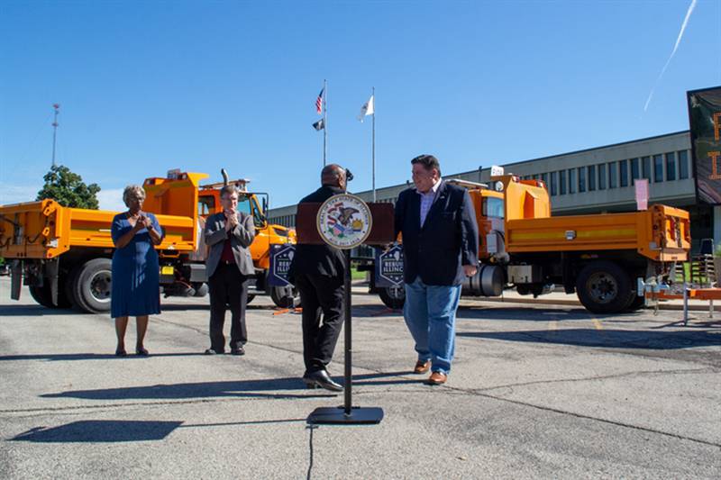 Gov. JB Pritzker shakes the hand of Illinois Department of Transportation Secretary Omer Osman outside the IDOT building in Springfield Friday. The pair and other local officials outlined the state's six-year infrastructure spending plan.