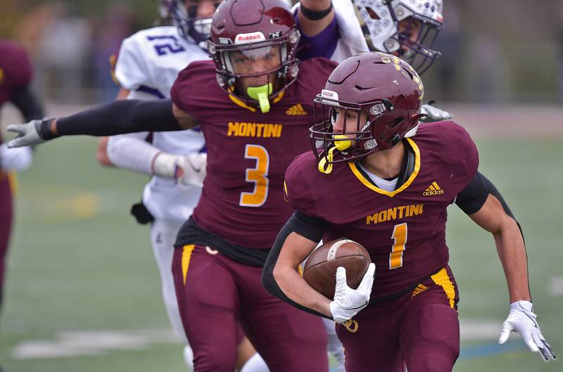 Montini's Santino Florio (1) is sprung for a touchdown by teammate Josiah James (3) who spreads his arms to hold off two Wilmington defenders during a Class 3A semifinal game on November 23, 2024 at Montini Catholic High School in Lombard.