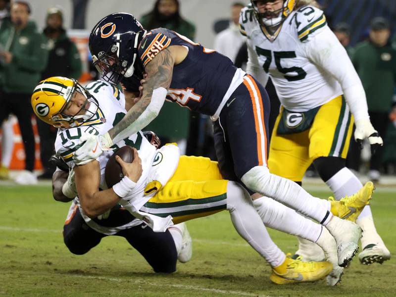 Chicago Bears defensive end Austin Booker (right) and defensive end Grady Jarrett bring down Green Bay Packers quarterback Jordan Love during their NFL Wild Card game Saturday, Jan. 10, 2026, at Soldier Field in Chicago.