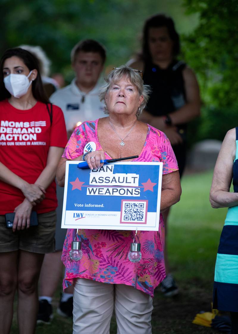 Patti Lackman of Batavia holds a sign calling to ban assault weapons during a candlelight vigil at the Kane County Courthouse in Geneva on Wednesday, July 6, 2022.  The vigil was organized to honor the mass shooting at a Fourth of July Parade in Highland Park.