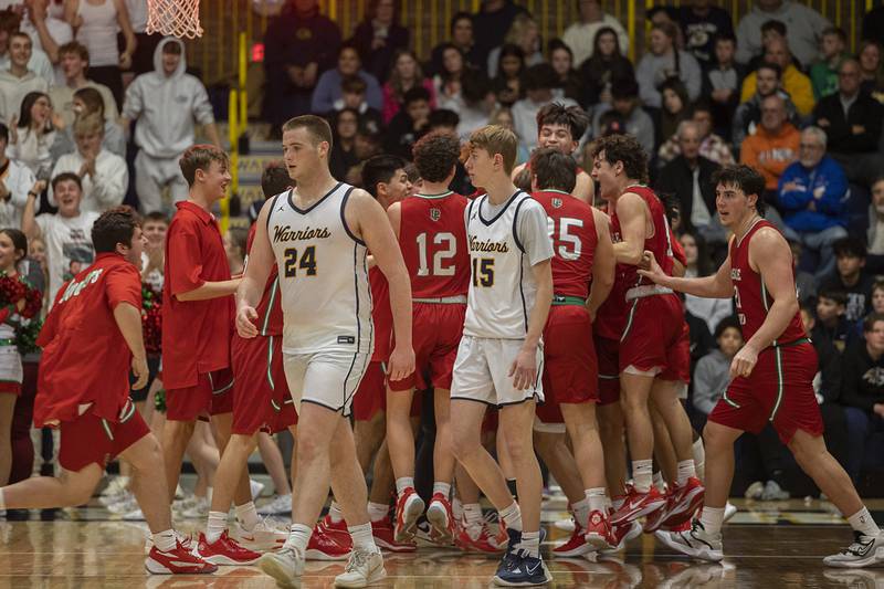 Sterling’s Lucas Austin and Rowan Workman walk off the court as LaSalle-Peru celebrates their win Friday, Feb. 23, 2024 during a class 3A regional final at Sterling High School.