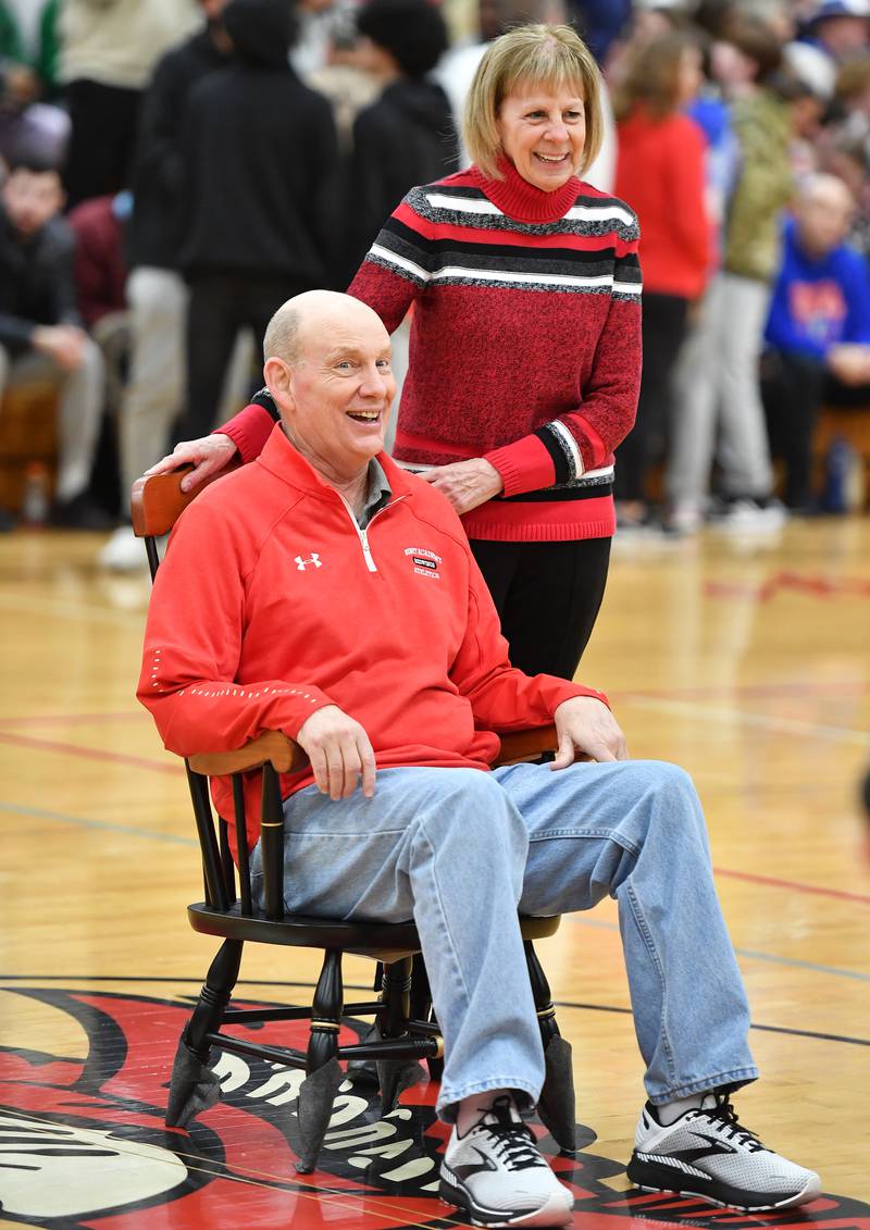 Recently retired Benet Academy Athletic Director Gary Goforth and his wife Paula share a laugh as he sits in his new chair presented to him during halftime ceremonies of a "When Sides Collide" invitational game on Jan. 21, 2023 at Benet Academy in Lisle.