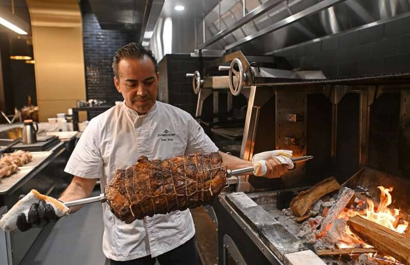 Chef José Sosa pulls a prime rib off the rotisserie at The Greggory in South Barrington.