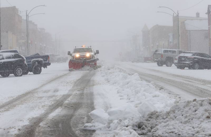 A plow pushes snow down the center of West St. Paul Street on Monday, March 16, 2026 in Spring Valley.