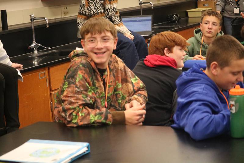James Caporali (left) is seen laughing after hearing the response to the question he raised on Monday, Nov. 10, 2025, for Edward Higgins during his Veterans Day visit to a classroom at Clinton Rosette Middle School in DeKalb. Higgins is a Vietnam War veteran from Rockford.