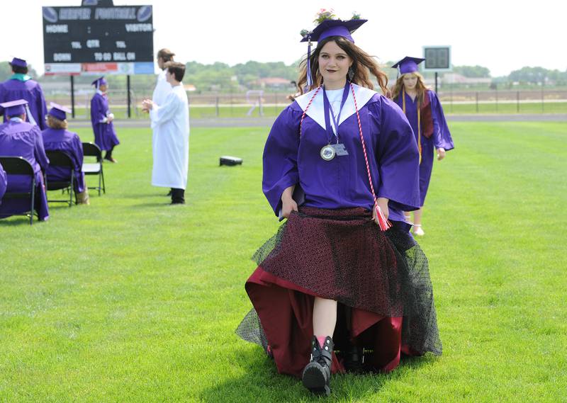 Alexandra Lemke manages her dress underneath her purple gown during Plano High School's graduation ceremony on the football field, Sunday, May 19, 2024.