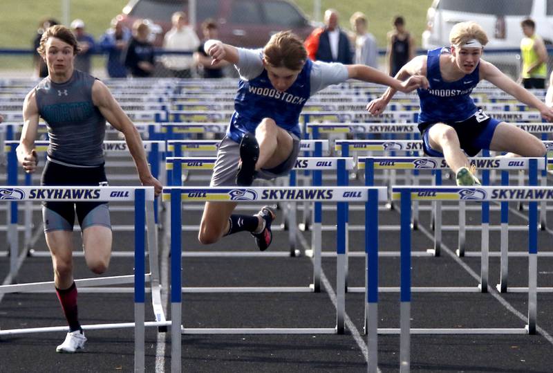 Woodstock’s Colton Medley (center) clears the last hurdle on the way to winning the 110 meter high hurdles in front of Woodstock North’s Braelan Creighton (left) and Woodstock’s Zach Kniola (right) during the Kishwaukee River Conference Boys Track and Field Meet on Tuesday, May 12, 2026, at Johnsburg High School.