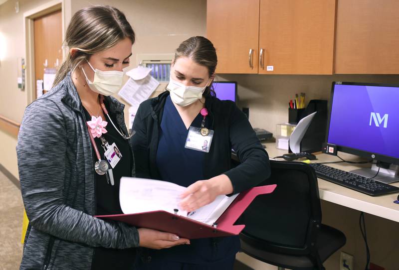 Travel nurses Alexandra Pop (left) and Taylor Zarris look over some paperwork Wednesday, March 23, 2022, at Northwestern Medicine Kishwaukee Hospital in DeKalb.