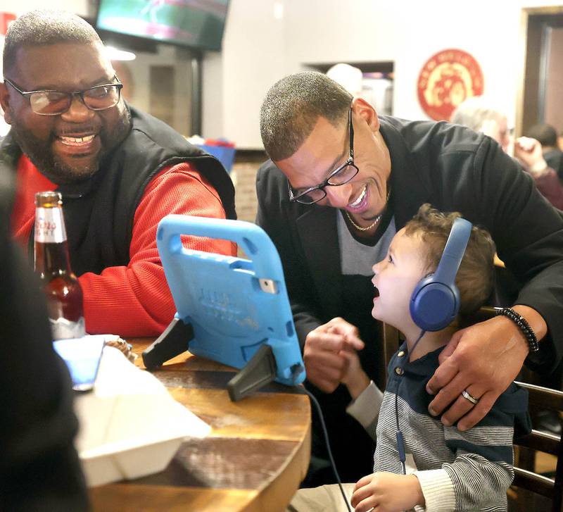 John Walker, (middle) DeKalb 7th Ward aldermanic candidate, greets friends Kaisen Gay, 2, and his dad Antwione Gay, from DeKalb Tuesday, April 4, 2023, during an election night watch party at Fatty's Pub & Grill in DeKalb.