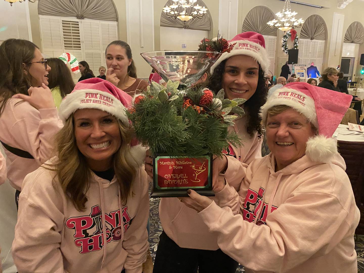 Members of Pink Heals Joliet Area Chapter hold the trophy for their winning martini, "Ralphie's Pink Dream," at Martinis, Mistletoe & More held at the Renaissance Center in Joliet on Monday, Dec. 5, 2022.