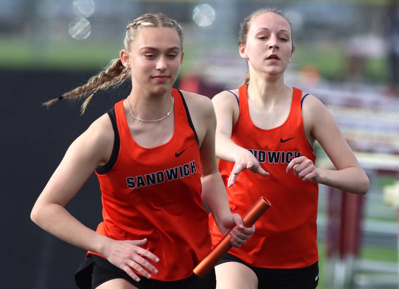 Sandwich’s Emily Urbanski, right, hands off to Kayla Kressin in the 3200-meter relay in KRC Conference Track Meet action at Marengo High School in Marengo on Tuesday, May 6, 2025.