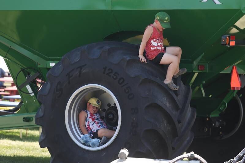 Jack Sinka, top, and his brother Mitchell play on a large trackor tire at the Will County Fair on Sunday, August 25, 2024 in Peotone.