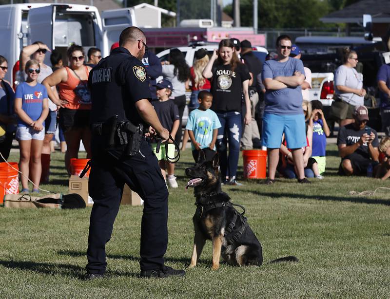People watch as McHenry Police Department Office Josh Conway and his K-9 partner, Eli, put on a demonstration during National Night Out! Tuesday, August 9, 2022, at Petersen Park in McHenry. The event was put on by the McHenry County Sheriff’s Office, City of McHenry Police Department and the McHenry County Conservation District and featured demonstrations, food and fun activities. National Night Out is held nationally in over 50,000 cities and is designed to help create relationships between neighbors and law enforcement community.