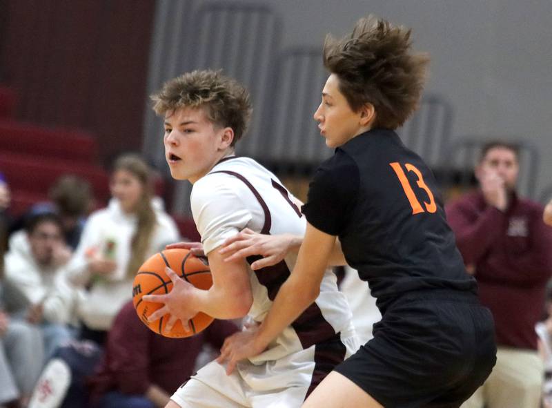 Marengo’s Blake Ritter, left, works past Sandwich’s Kevin Surd  in varsity boys basketball action on Saturday, Jan..24, 2025, at Marengo High School in Marengo.