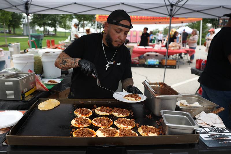 Rey Cespenda works the grill at Spin Taco’s food tent at Taco Fest on Saturday, July 15th, 2023 in New Lenox.