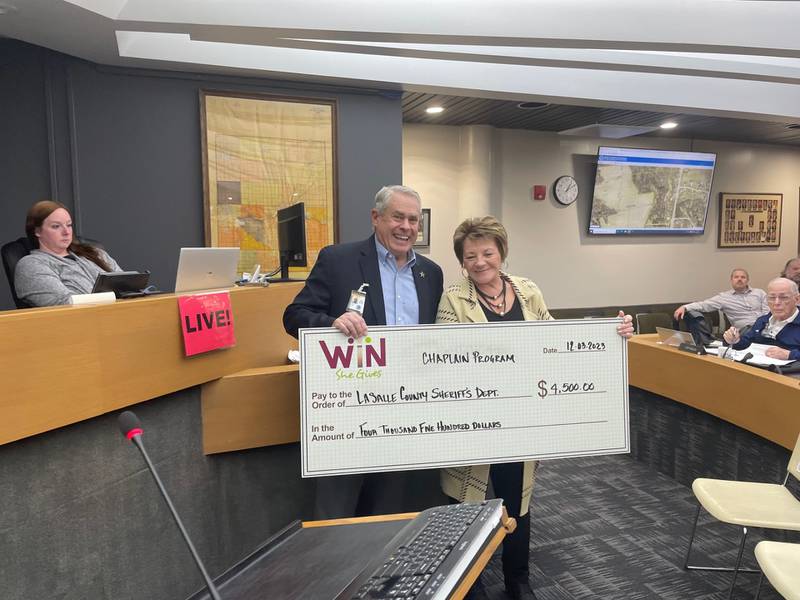 La Salle County Sheriff's Chaplain Dave Van Laar (left) and board member Pamela Beckett (D-Ottawa) celebrate Monday, Dec. 4, 2023, the $4,500 grant the sheriff's office was awarded to expedite relief services.