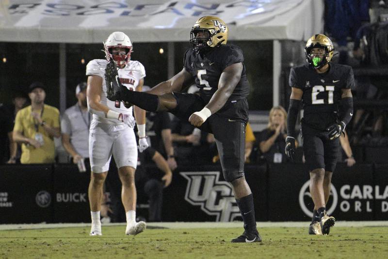 Central Florida defensive tackle Ricky Barber (5) celebrates after making a tackle during the second half of an NCAA college football game against Louisville in Orlando, Fla. (AP Photo/Phelan M. Ebenhack)