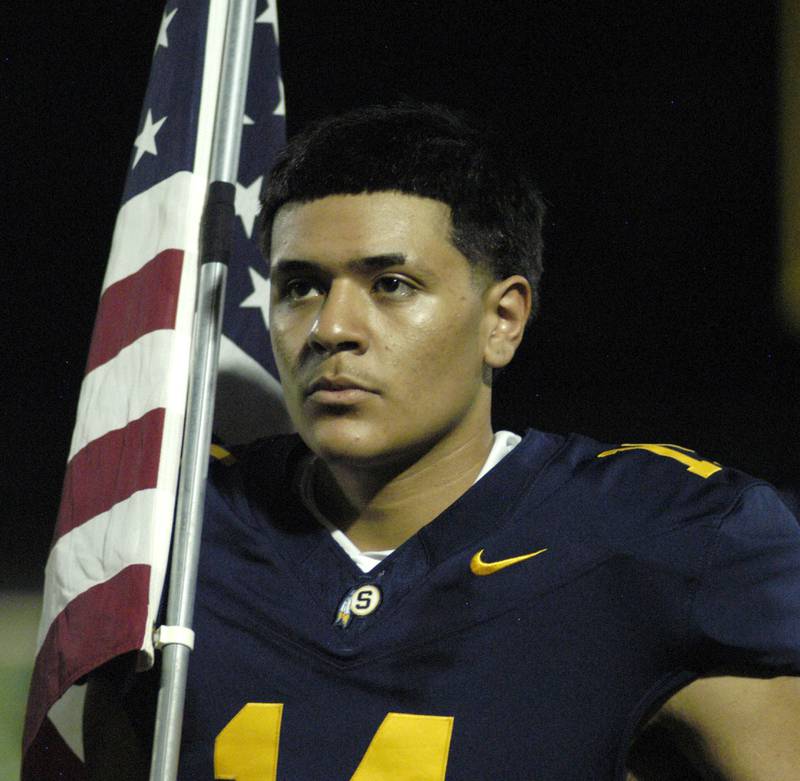 Aaron Sandoval holds the flag during the National  Anthem Friday night. The Galesburg Silver Streaks traveled to Sterling to take on the Warriors at Prescott Memorial Field at Roscoe Eades Stadium, September 26, 2025.