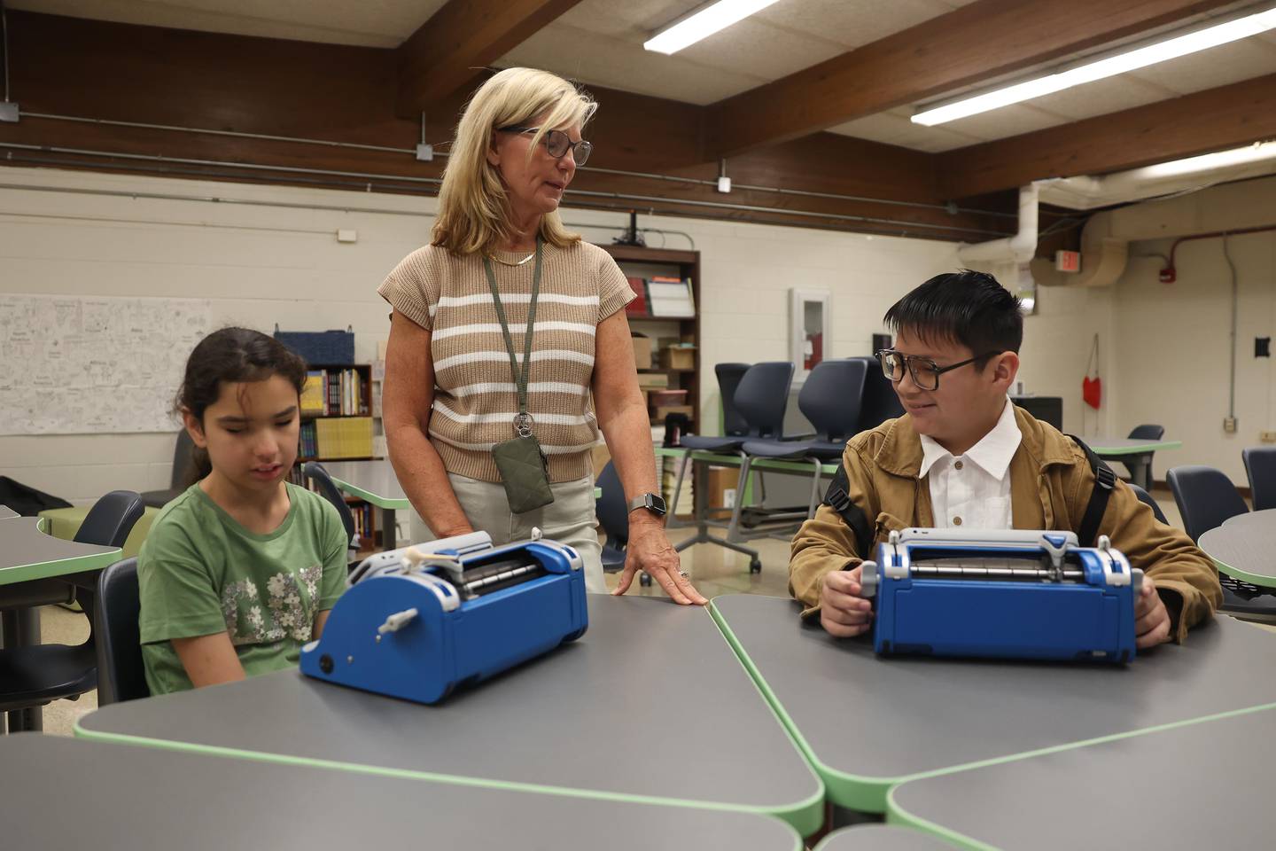 Becky Nahas, center, works with Giuliana Ciangiola and Angel Rodriguez Vazquez on their Perkins SMART Brailler on the first day of school at Dirksen Junior High School on Wednesday, August 21, 2024 in Joliet.