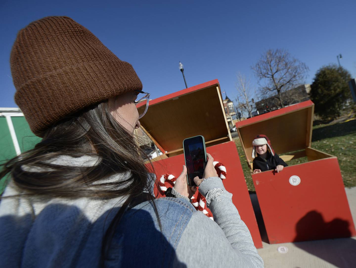 Atlas Rodriguez pops out of a toy box next to Santa’s house Saturday, Nov. 26, 2022, as his mother Ashley Bailey takes his photo at the Chris Kringle Market.