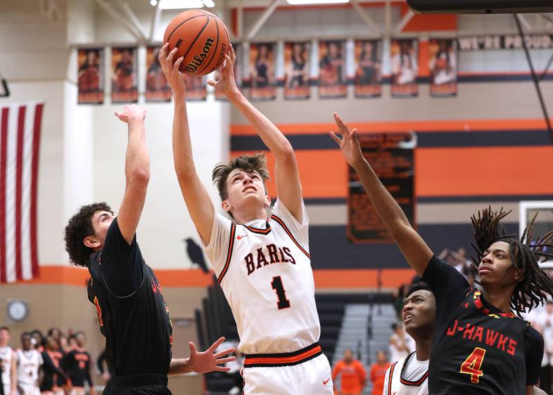 DeKalb’s Jackson Kees grabs a rebound between two Jefferson defenders Wednesday, Feb. 21, 2024, during their Class 4A regional semifinal game at DeKalb High School.
