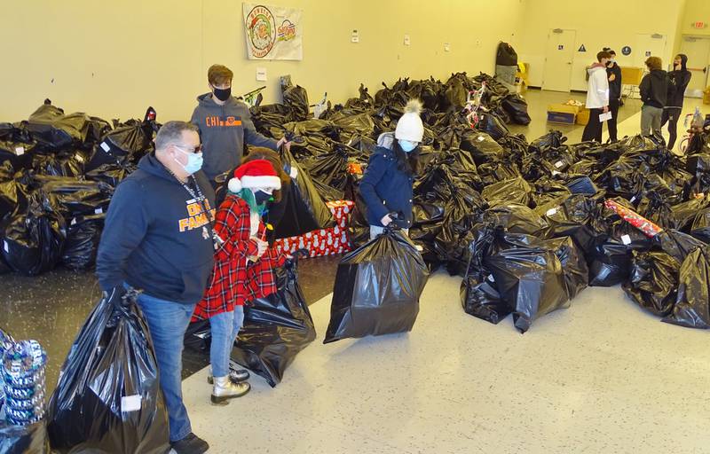 Rotary Secret Santa volunteers grab bags stuffed with toys on delivery day in December 2020