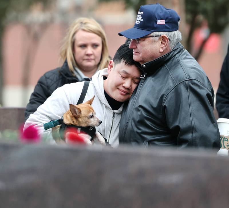 Larry Gehant, uncle of shooting victim Julianna Gehant, hugs Harold Ng, an NIU graduate and 2008 shooting survivor, during a remembrance ceremony Tuesday, Feb. 14, 2023, at the memorial outside Cole Hall at Northern Illinois University for the victims of the mass shooting in 2008. Tuesday marked the 15th year since the deadly shooting that killed five students and injured dozens more.