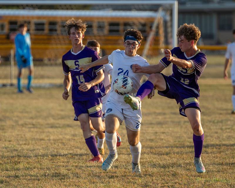 Thomas Pecerill (12) of Serena kicks ball above torso of Nolan Kerley (24) of Somonauk/Leland/Newark as he guards Pecerill on Monday, Sept. 29, 2025, at Serena High School in Serena.
