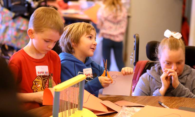 Grace McWayne Elementary School first graders Elijah Hammar and Landon Faiola make valentines with Marklund Hyde Center resident Katie B. on Wednesday, Feb. 7, 2024.