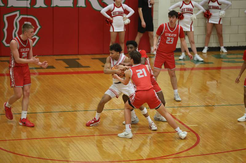 Ottawa's Hezekiah Joachim wins a jump ball over Streator's Sharonn Morton and Joseph Hokestra during the Class 3A Regional semifinal game on Wednesday, Feb. 25, 2026 in Sellett Gymnasium at L-P High School.
