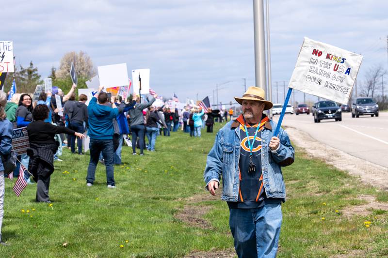 Protesters hold up protest signs along Randall Road in South Elgin, IL to protest their issues with President Donald J. Trump and his administration and Elon Musk involvement in US government affairs on Saturday April 19, 2025.  Hundreds of protesters participated in the latest Hands Off protest occurring in the Chicagoland area and the rest of the country.