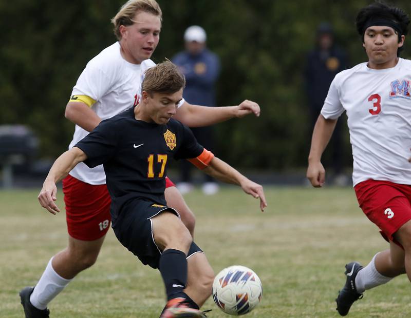 Richmond-Burton's Joseph Kyes shoots for a goal between Marian Central's Finn Piefer (left)  and Christopher John Fragante (right) during the IHSA Class 1A Marian Central Regional Boys Soccer Final match on Tuesday, Oct. 22, 2024, at Marian Central High School in Woodstock.