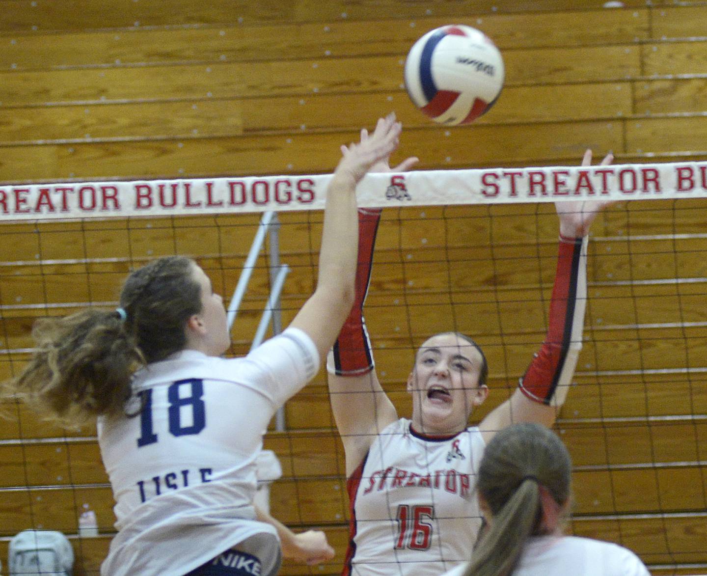 Streator’s Sophia Snow,sets to block a shot by Lisle’s Alaina Schroeder in the 1st set Tuesday during match at Streator.