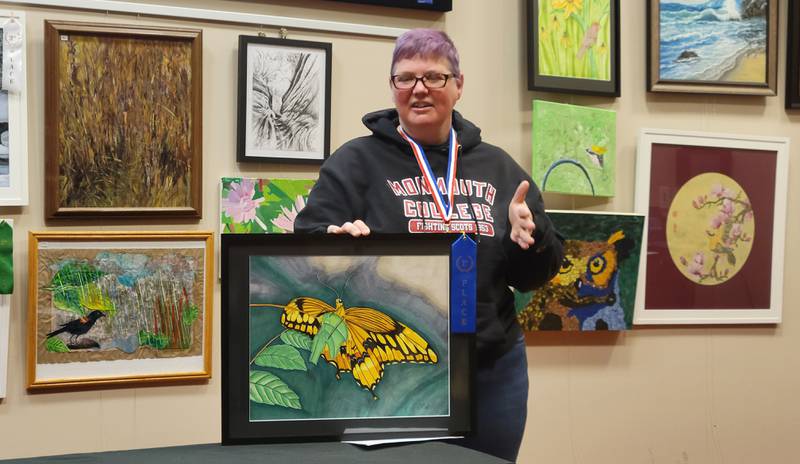 Norway's Carrie Woeltje discusses on Sunday her marker drawing of a giant swallowtail butterfly, the winning entry in the annual Starved Rock Art Show.