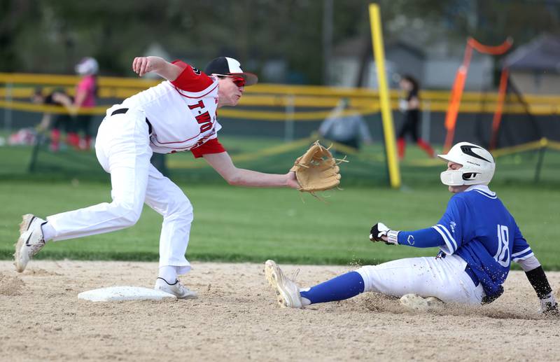 Hinckley-Big Rock's McKinley Shelton slides in safely with a stolen base as the throw goes wide of Indian Creek's Jakob McNally during their game Monday, April 29, 2024, at Indian Creek High School.