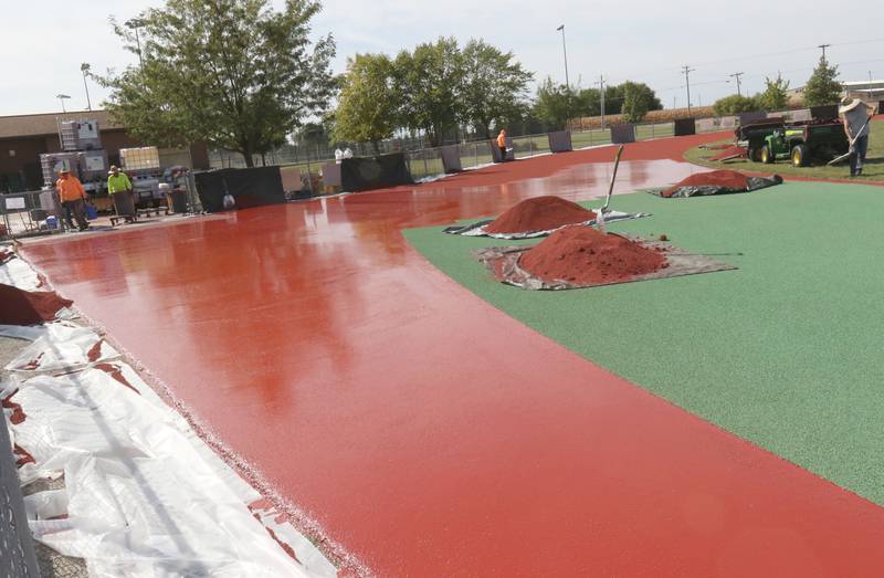 Crews with Track Surfaces Company in Elburn, dump red dyed paint onto the La Salle-Peru Township High School Track on Tuesday, Sept. 23, 2025 at the La Salle-Peru Township High School Athletic Complex in La Salle. Crews have been resurfacing the track for the past week. LaSalle-Peru Township High School Sports Complex will be closed to the public for approximately four weeks while the track undergoes resurfacing work. The track was first installed in 2014.